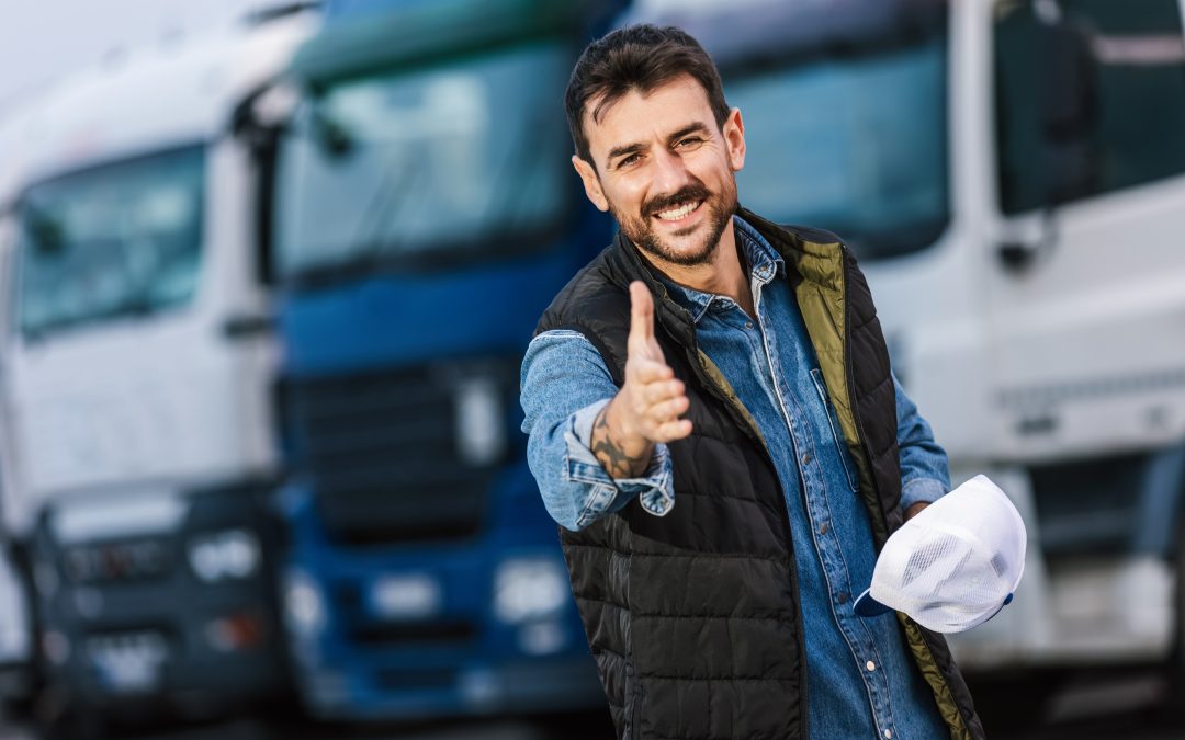 trucker in front of freight trucks reaching out to shake a hand